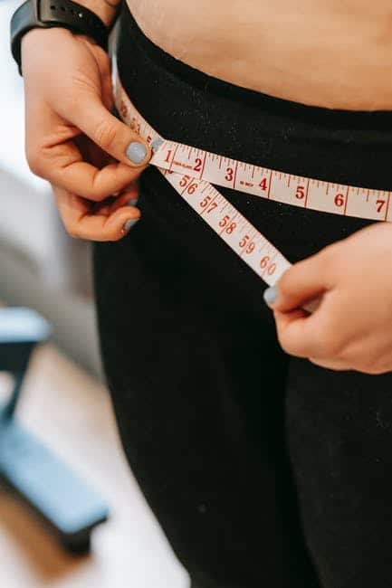 Woman measuring her waist after weight loss