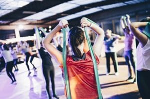 Woman using resistance bands at a gym.