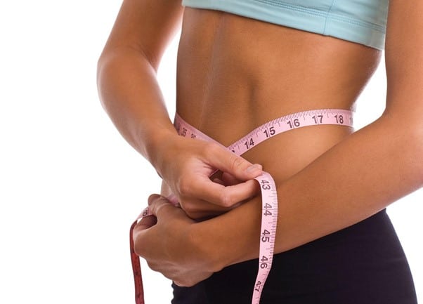 Woman measuring her belly with a tap checking for weight loss